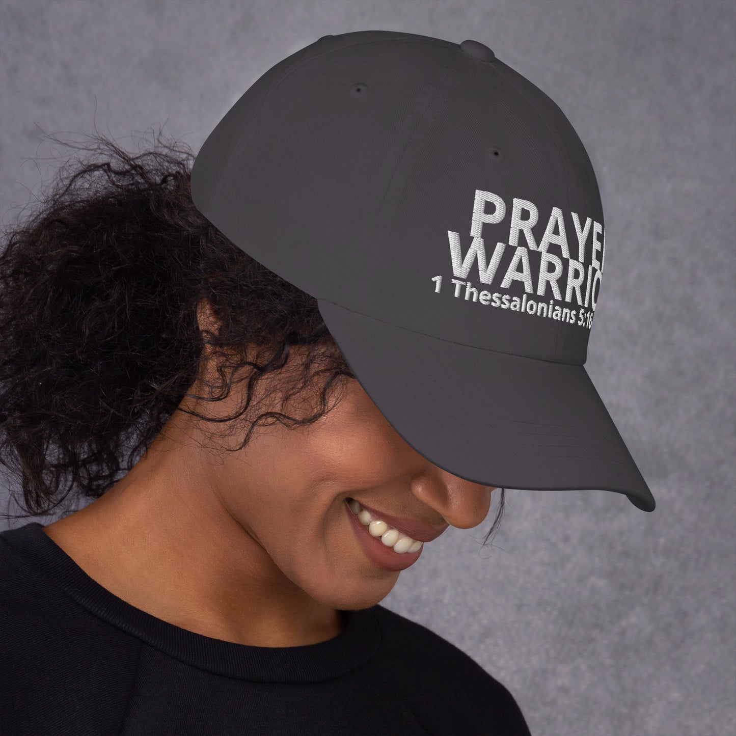 A person wearing a Prayer Warrior black cap – 1 Thessalonians 5:16–17 KJV embroidered Christian hat, adjustable unisex, grey, faith-based headwear by ReBirth Living