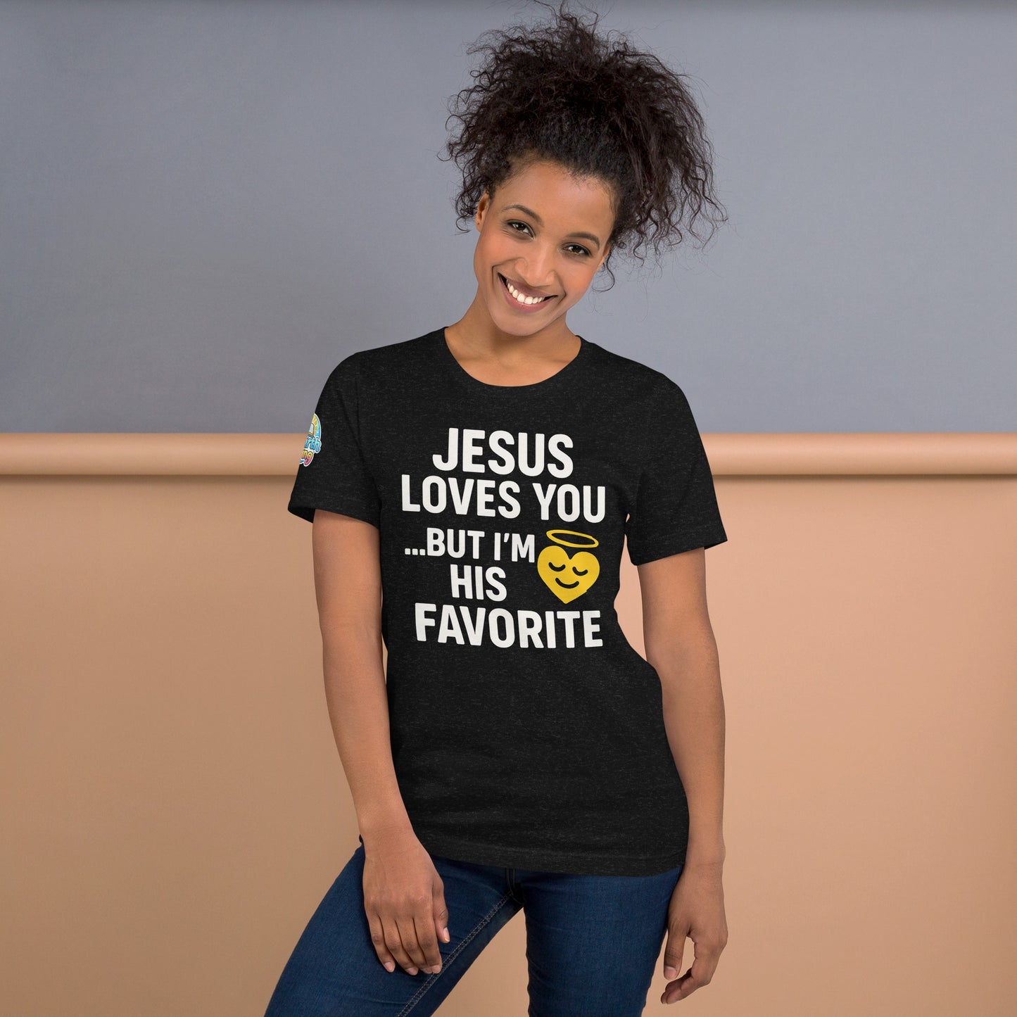 Model wearing “Jesus Loves You… But I’m His Favorite” – funny Christian t-shirt, black heather, faith humor design with golden smiling heart and halo by ReBirth Living