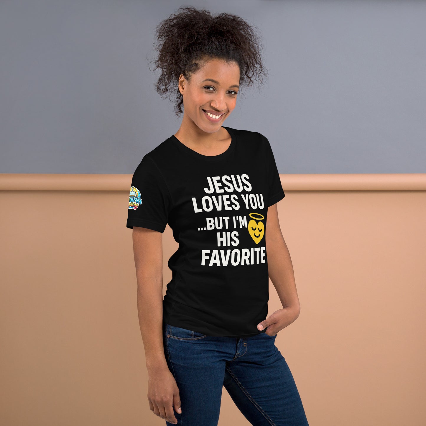 Model wearing “Jesus Loves You… But I’m His Favorite” – funny Christian t-shirt, black, faith humor design with golden smiling heart and halo by ReBirth Living
