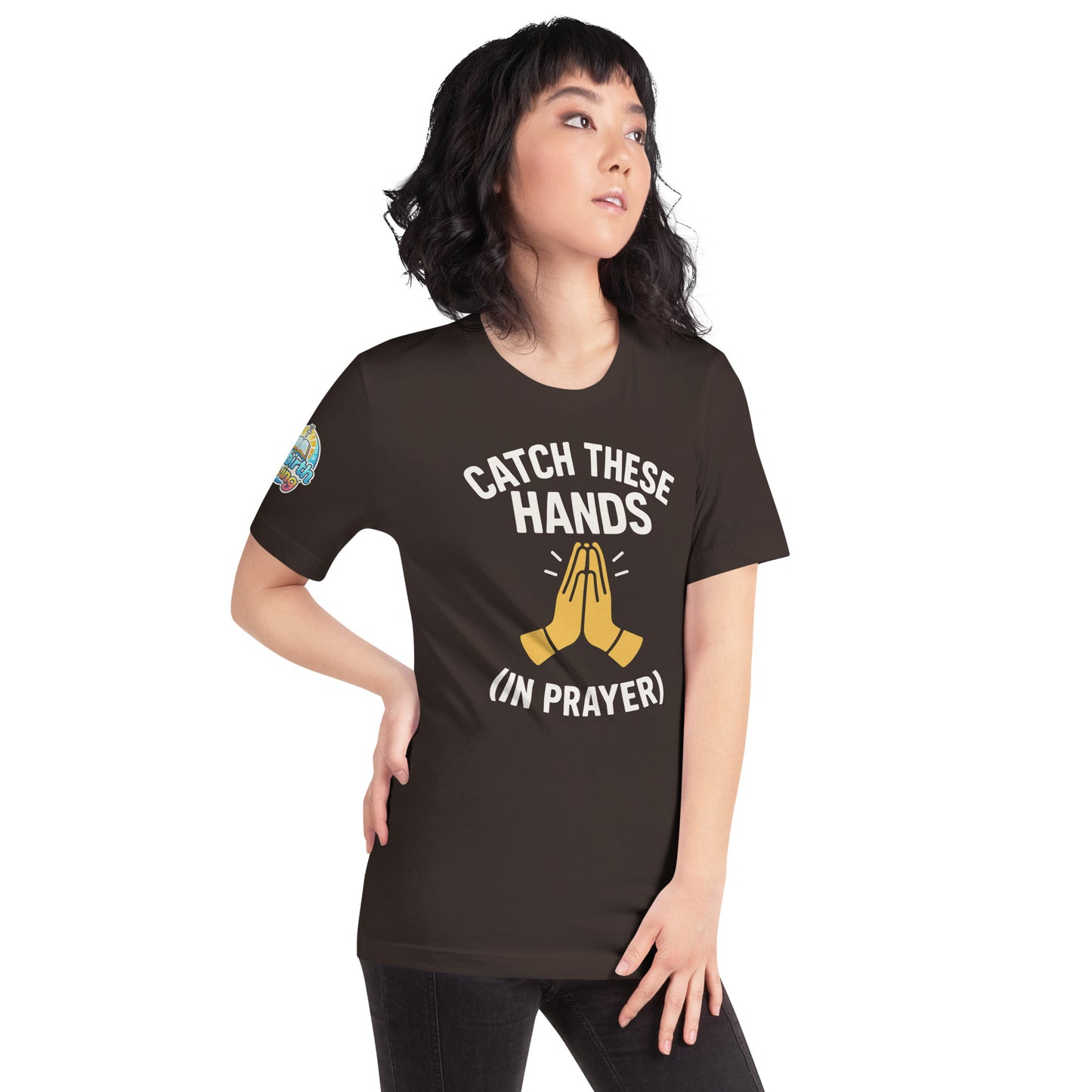 Model wearing “Catch These Hands (In Prayer)” – funny Christian t-shirt, brown, faith-based humor design with golden praying hands by ReBirth Living