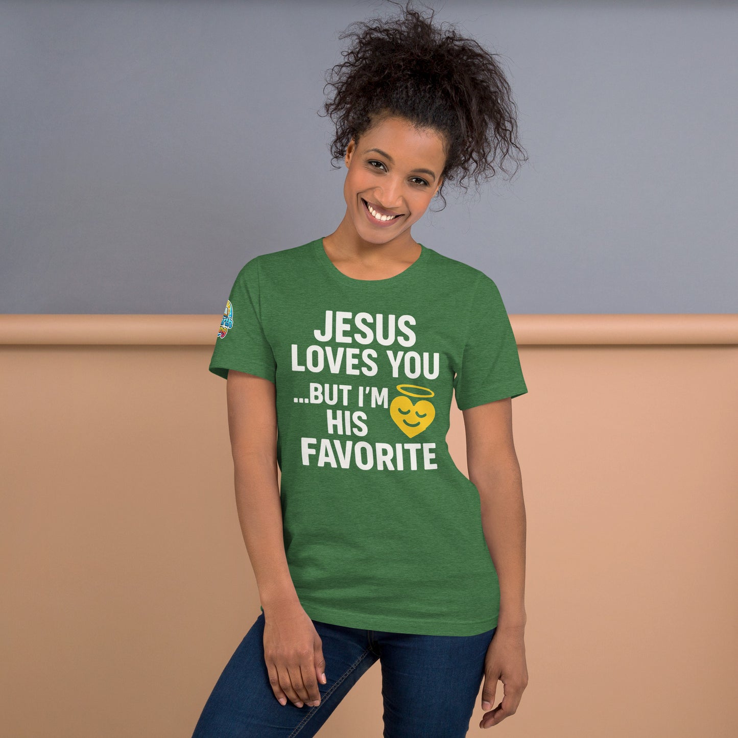 Model wearing “Jesus Loves You… But I’m His Favorite” – funny Christian t-shirt, heather grass green, faith humor design with golden smiling heart and halo by ReBirth Living