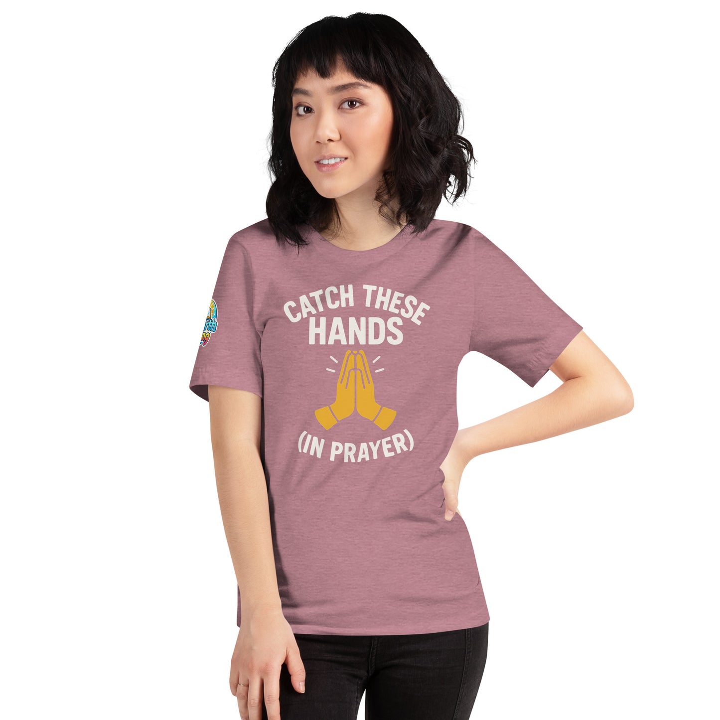 Model wearing “Catch These Hands (In Prayer)” – funny Christian t-shirt, heather orchid, faith-based humor design with golden praying hands by ReBirth Living