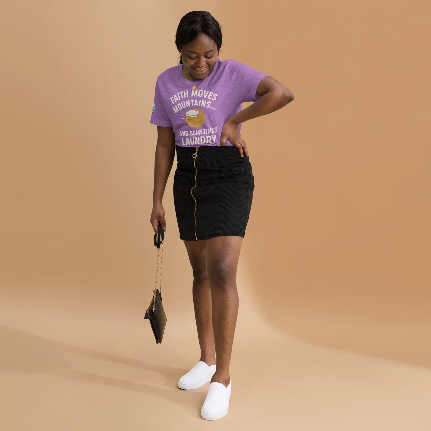 Model showcasing a Faith Moves Mountains… and Sometimes Laundry – funny Christian t-shirt, heather team purple, faith-based humor design by ReBirth Living