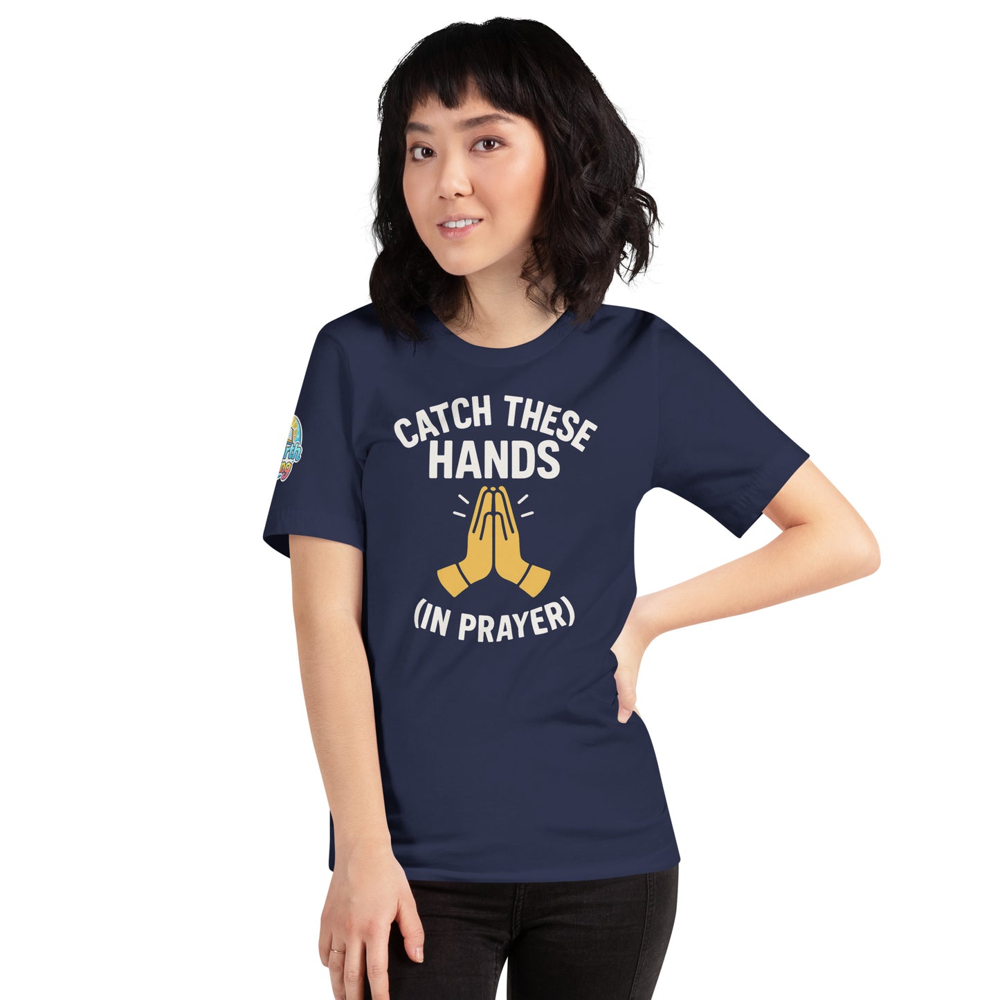 Model wearing “Catch These Hands (In Prayer)” – funny Christian t-shirt, navy, faith-based humor design with golden praying hands by ReBirth Living