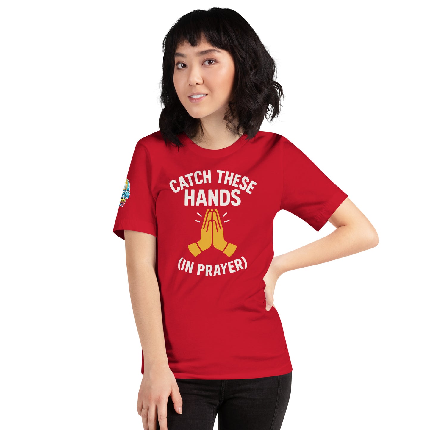 Model wearing “Catch These Hands (In Prayer)” – funny Christian t-shirt, red, faith-based humor design with golden praying hands by ReBirth Living