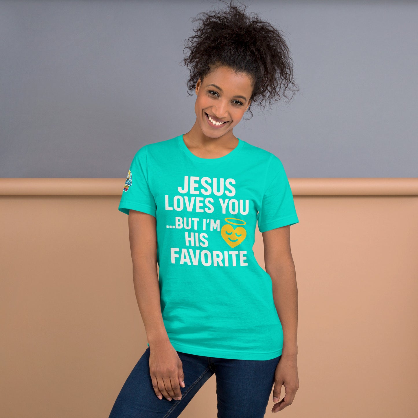 Model wearing “Jesus Loves You… But I’m His Favorite” – funny Christian t-shirt, teal, faith humor design with golden smiling heart and halo by ReBirth Living
