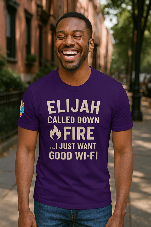 Man wearing a purple t-shirt with humorous text outdoors. Elijah Called Down Fire… I Just Want Good Wi-Fi – funny Christian t-shirt, purple, Bible humor design by ReBirth Living