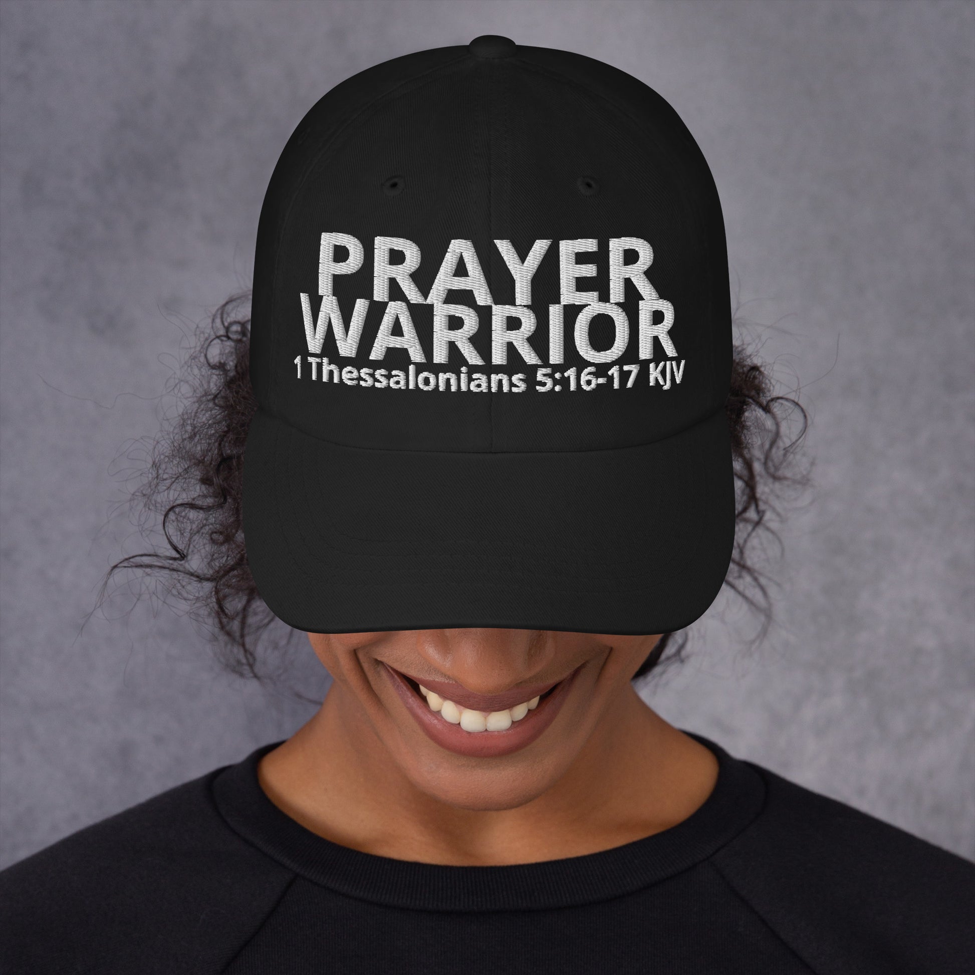 A person wearing a Prayer Warrior black cap – 1 Thessalonians 5:16–17 KJV embroidered Christian hat, adjustable unisex, black, faith-based headwear by ReBirth Living