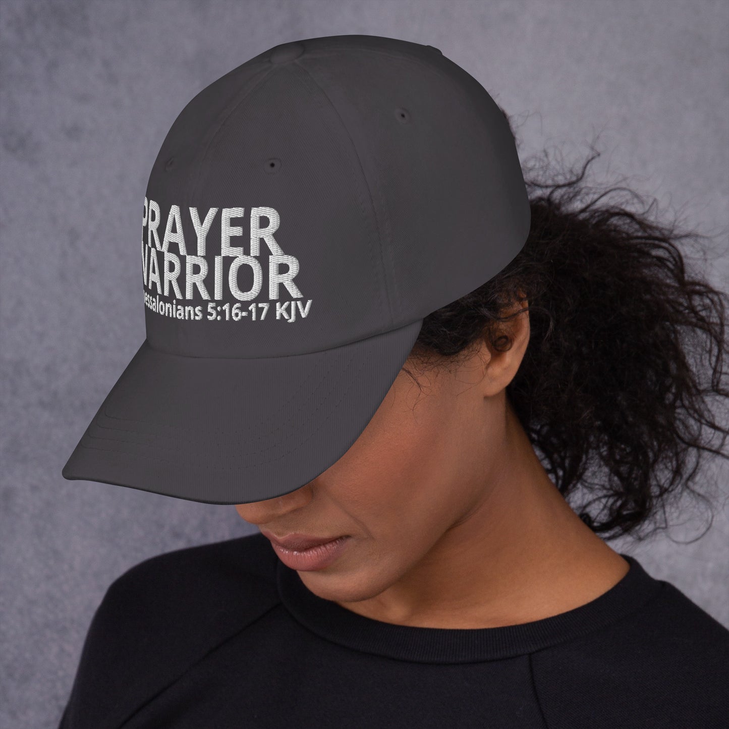 A person wearing a Prayer Warrior black cap – 1 Thessalonians 5:16–17 KJV embroidered Christian hat, adjustable unisex, grey, faith-based headwear by ReBirth Living