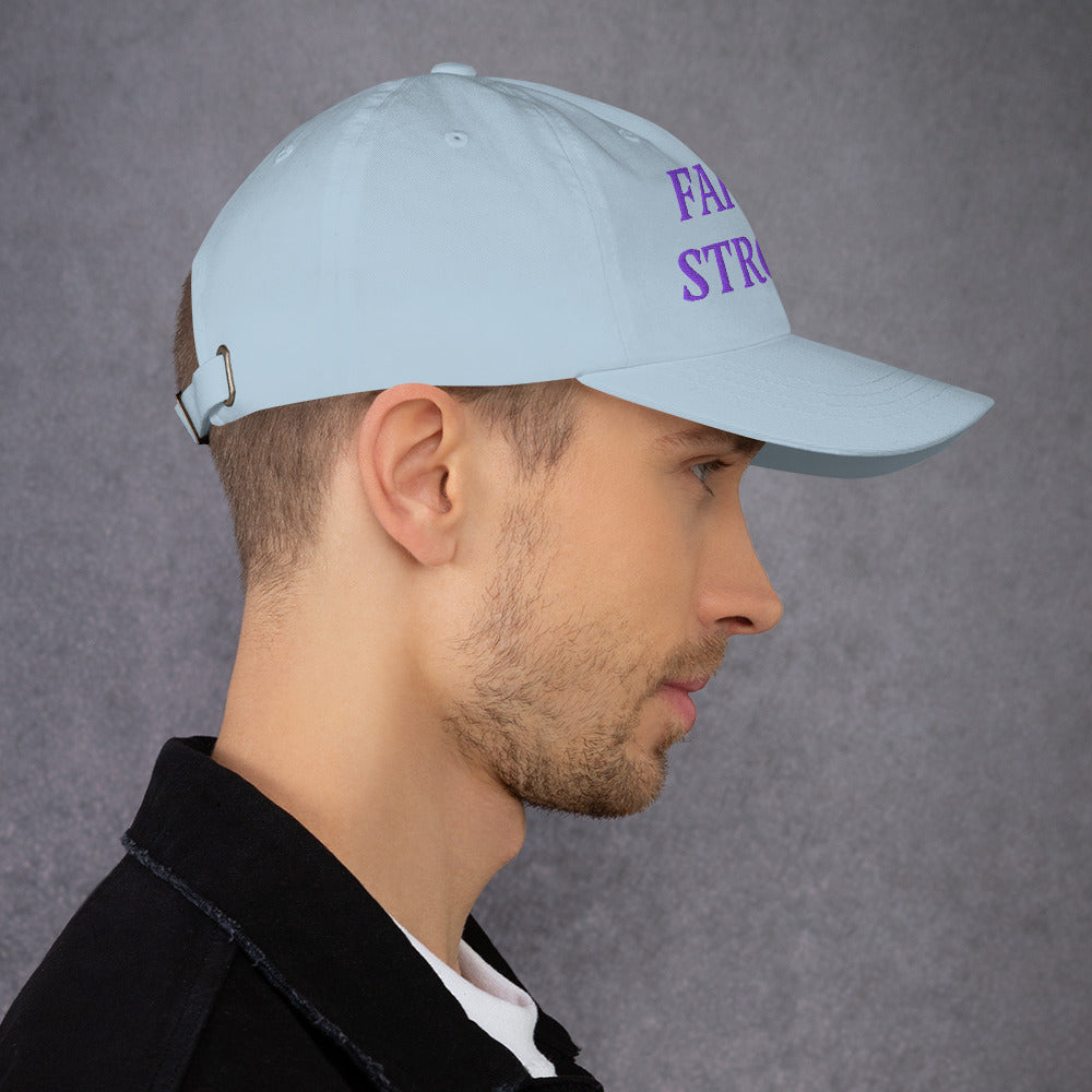Model is wearing a Faith Strong embroidered hat – bold purple text, light blue adjustable unisex cap by ReBirth Living