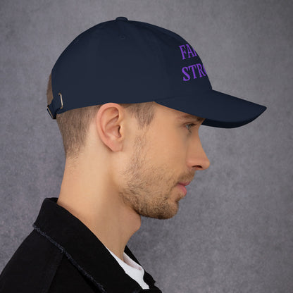 Model is wearing a Faith Strong embroidered hat – bold purple text, navy adjustable unisex cap by ReBirth Living