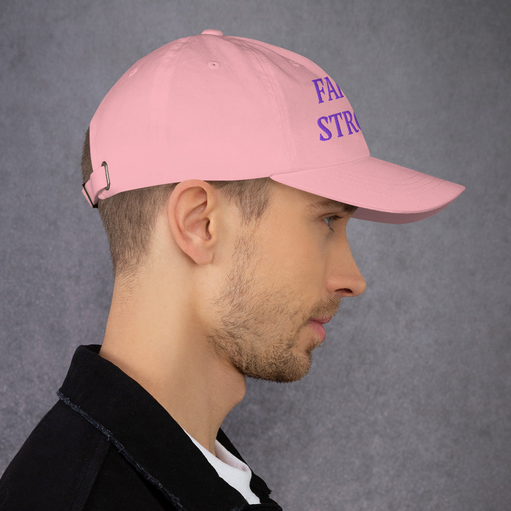 Model is wearing a Faith Strong embroidered hat – bold purple text, pink adjustable unisex cap by ReBirth Living