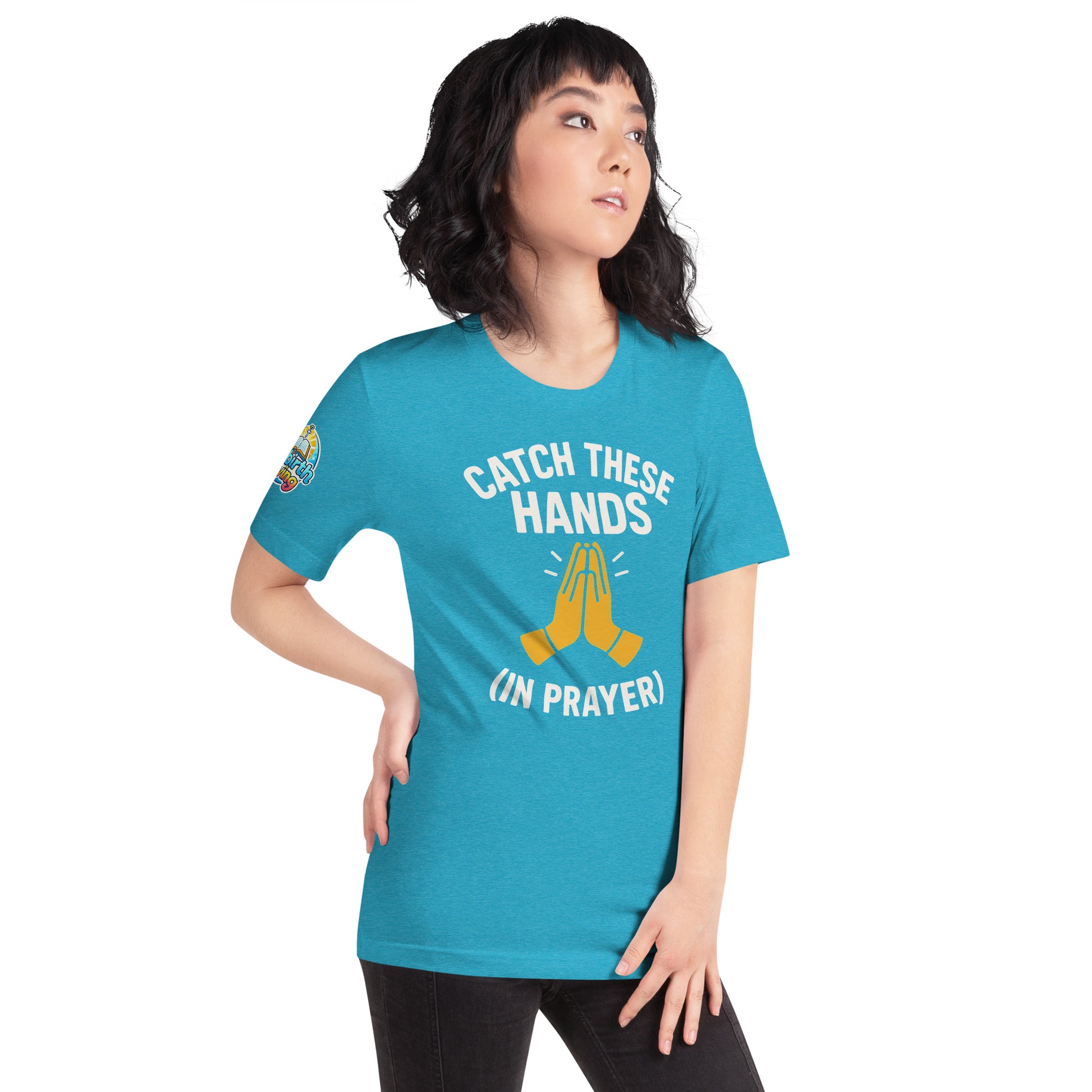 Model wearing “Catch These Hands (In Prayer)” – funny Christian t-shirt, heather aqua, faith-based humor design with golden praying hands by ReBirth Living